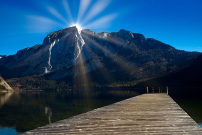 Scenic view of lake and mountains against blue sky