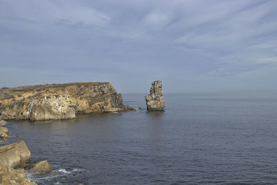 Scenic view of rocks in sea against sky