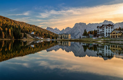 Scenic view of lake and mountains against sky during sunset