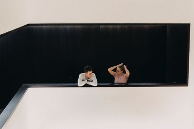 Rear view of couple sitting on table