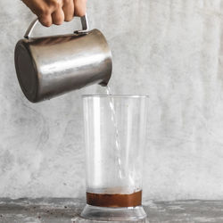 Close-up of hand pouring drink in glass