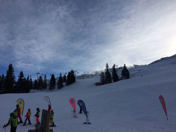 People enjoying in snow against sky