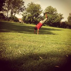 Side view of man jumping on field