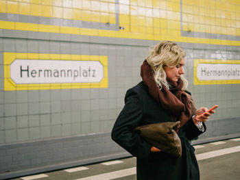 Beautiful woman using phone at railroad station