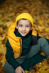 Portrait of smiling young man sitting on plant