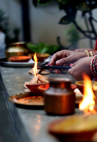 Cropped hands of woman igniting incense