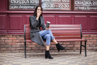 Full length of woman sitting on bench