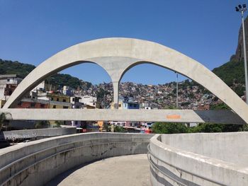 Arch bridge in city against clear sky