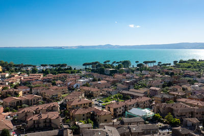 High angle view of townscape by lake bolsena against sky