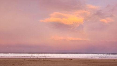 Scenic view of beach against sky during sunset