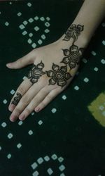 Cropped image of woman hand showing henna tattoo on fabric