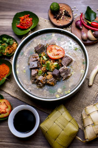 Coto makasar and ketupat, indonesian traditional food, taken with high angle view on table