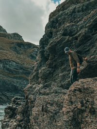 Midsection of person on rock against sky