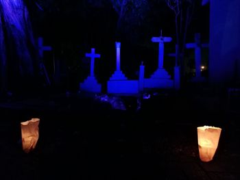 Lit candles in cemetery at night