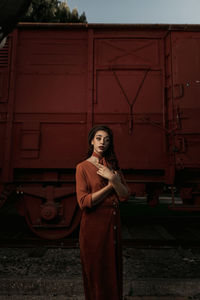 Portrait of young woman standing against the wall