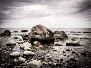 Rocks in sea against sky