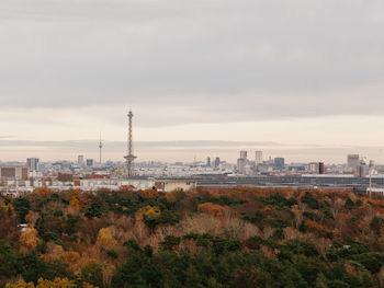 View of buildings in city against cloudy sky