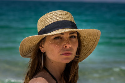 Portrait of woman wearing hat against sea