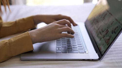 Midsection of woman using laptop on table