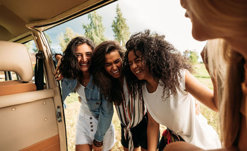 Happy female friends near van