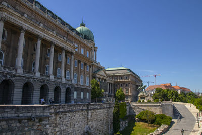 Buildings in city against clear blue sky