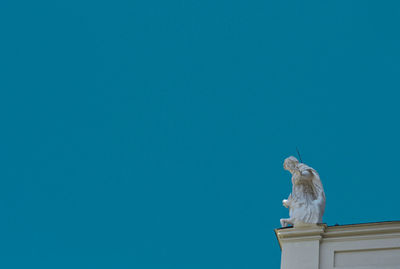 Low angle view of statue against clear blue sky