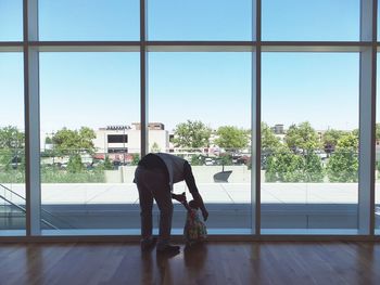 Man holding baby girl by window