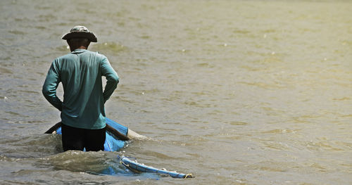 Rear view of man standing at beach