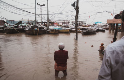 Rear view of people on boat moored in river