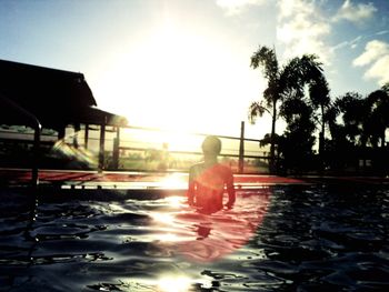 Rear view of man swimming in pool