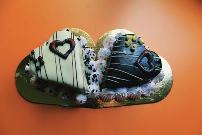Close-up of heart shape cakes against orange background