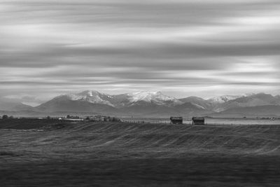 Scenic view of land and mountains against sky
