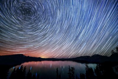 Scenic view of lake against sky at night