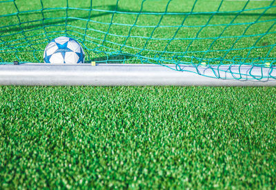 Soccer ball by net on field
