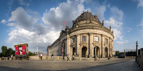 View of historic building in city against cloudy sky