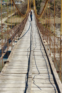 Mid distance view of man standing on footbridge