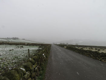 Road by landscape against sky