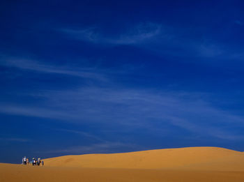 Scenic view of desert against blue sky