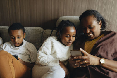 Young woman using mobile phone at home
