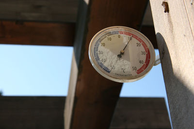 Low angle view of clock on wood