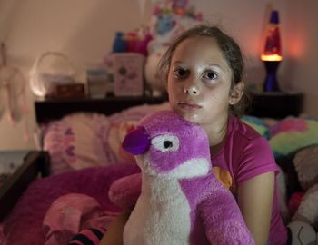 Portrait of girl with toy at home