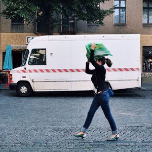 Woman carrying scrap by van