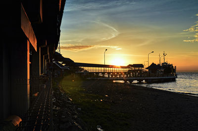 Pier over sea against sky during sunset
