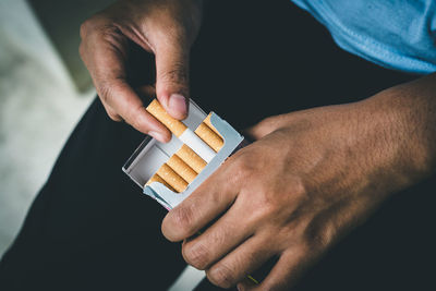 Close up man hand holding peel it off cigarette pack prepare smoking a cigarette. packing line up.