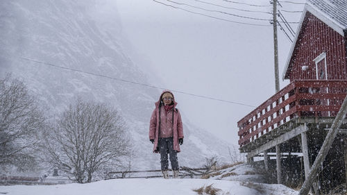 Rear view of woman standing on snow covered field