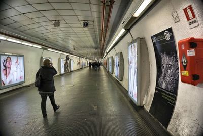 Rear view of people walking on train at subway station