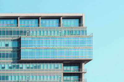 Low angle view of modern building against clear blue sky
