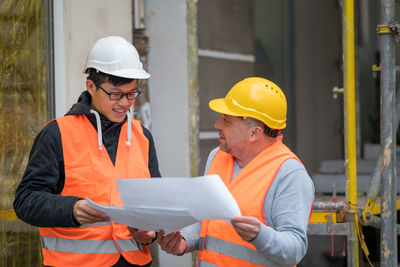 Engineers discussing while standing at construction site