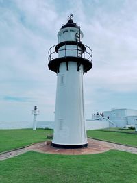 Lighthouse by sea against sky