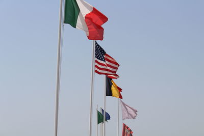 Low angle view of various flags against clear sky